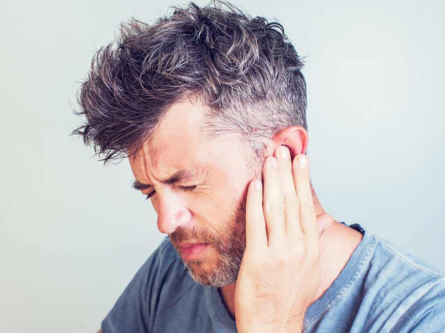 A man holds his ear because he has earache